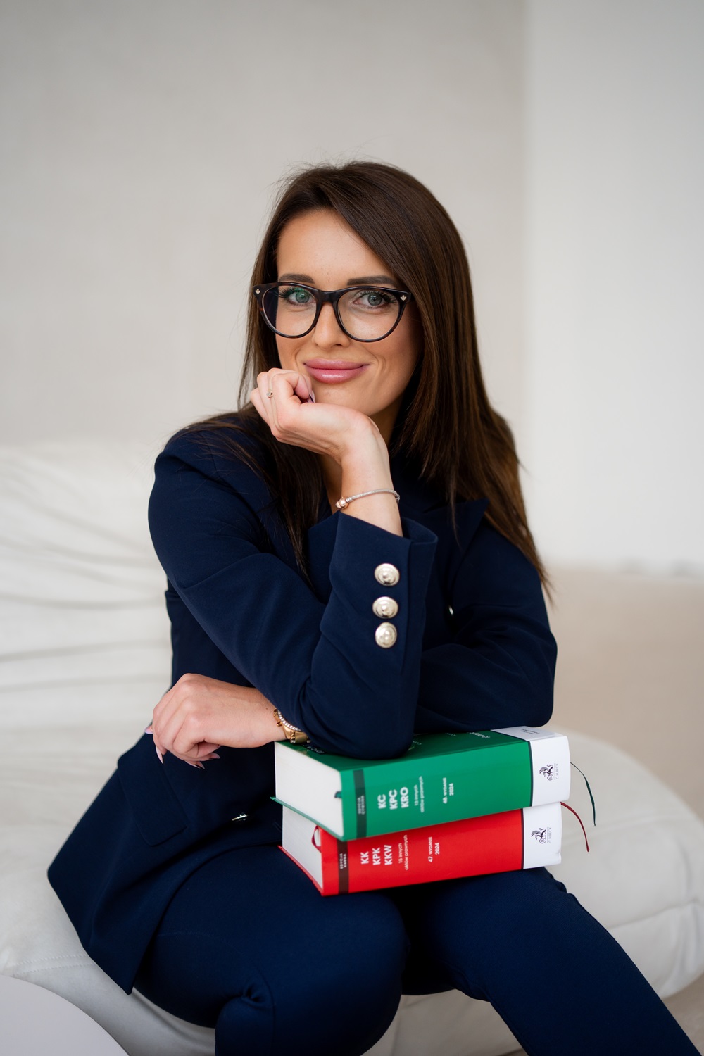 Zdjęcie przedstawia adwokat Patrycję Dzięgielewską z kodeksem karnym i cywilnym